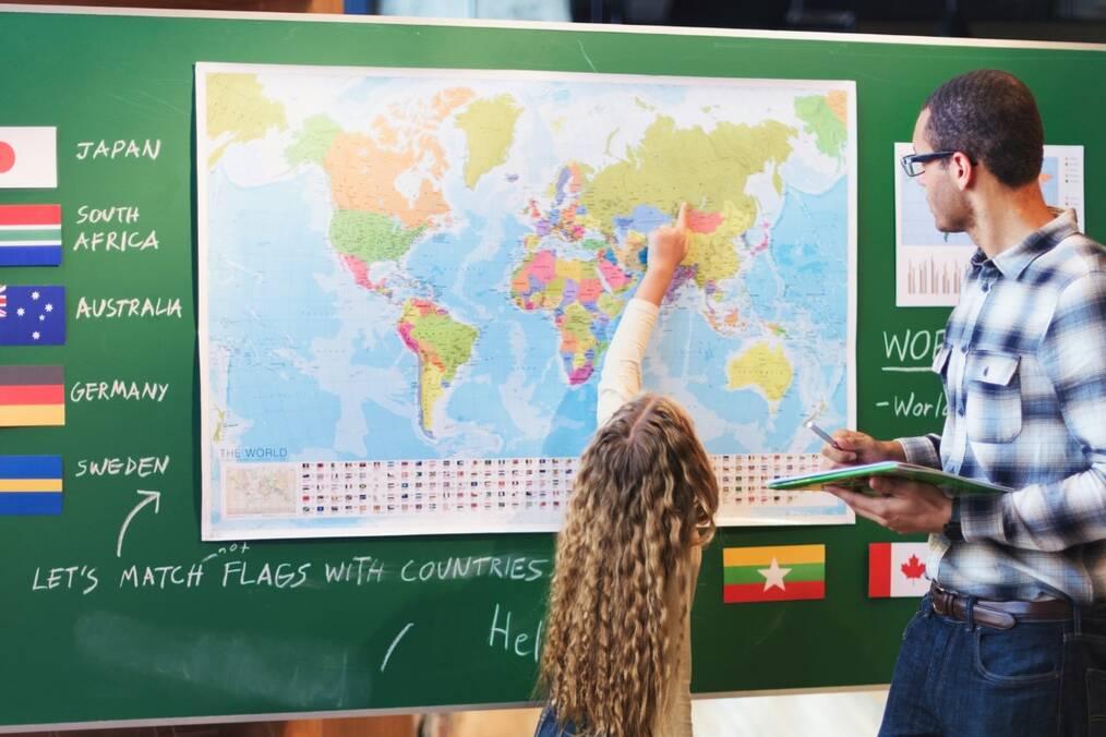 A student pointing on the world map